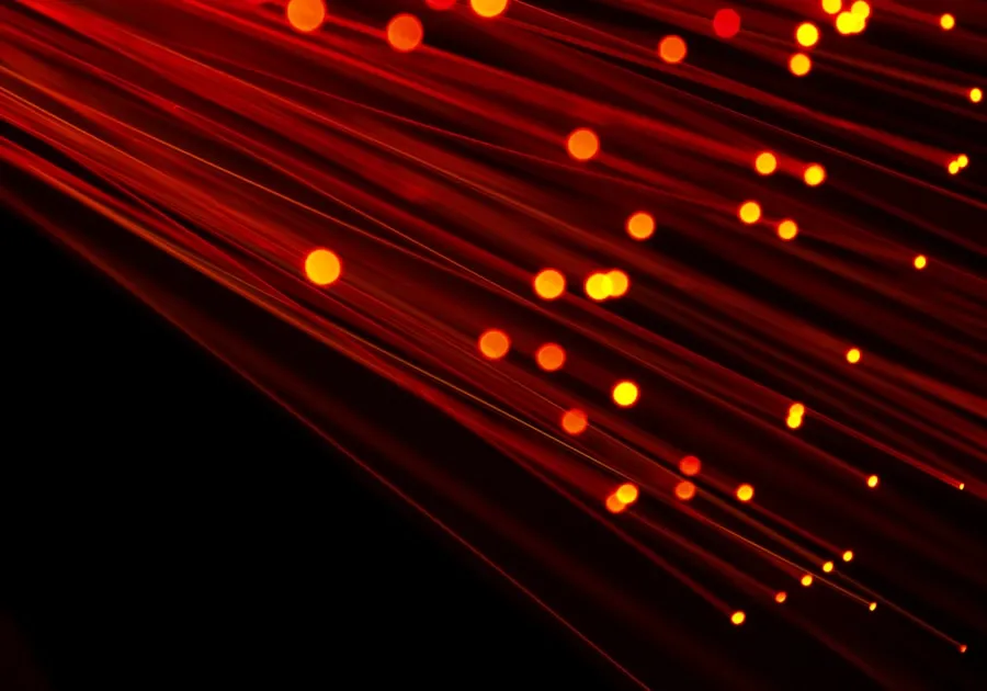 fiber optic light image with red hue on black background. Ideal image to depict broadband, technology, speed and cable inf...