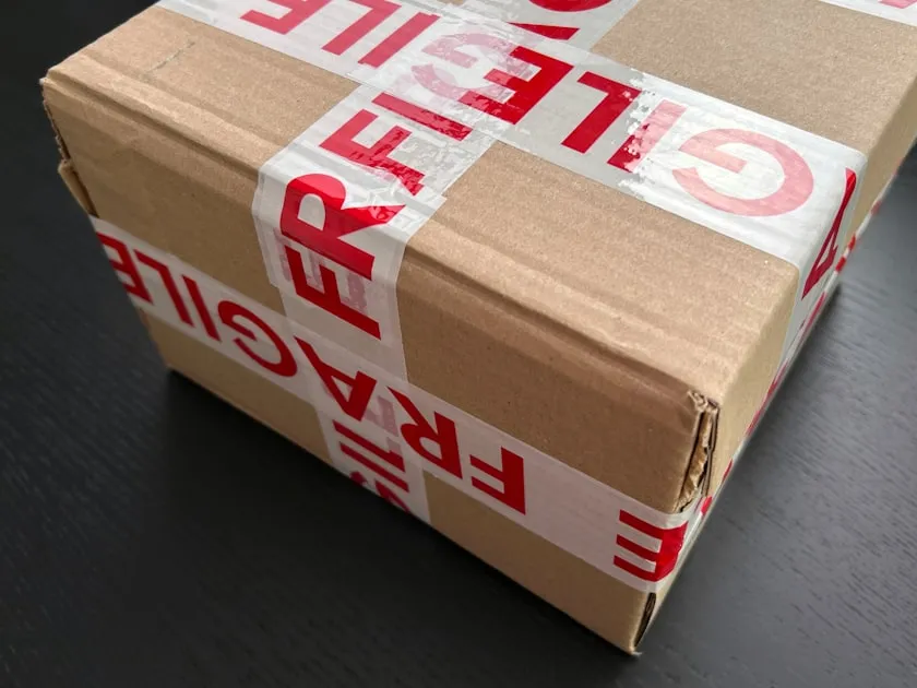 Cardboard box sealed with red fragile tape — Gửi Quà Về Quê Từ Ocean Park - Nhanh, An Toàn, Giá Rẻ