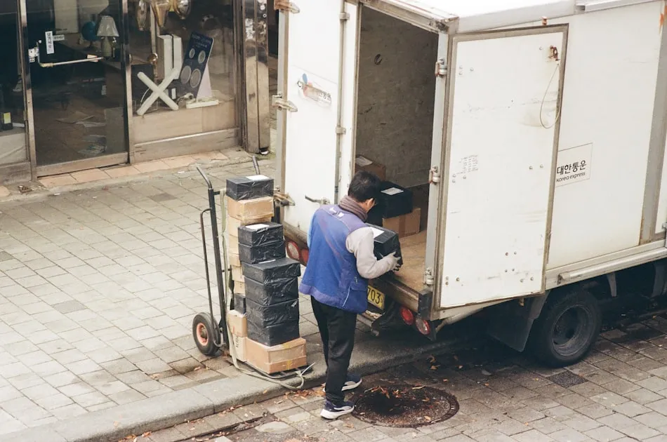 Man loading boxes from a truck onto a dolly — Khuyến Mãi Viettel Post Tháng 4/2026 - Giảm Phí Ship Đến 30%