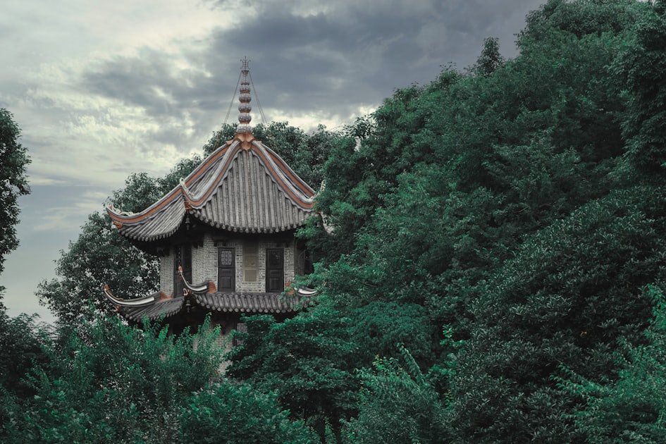 a tall building surrounded by trees under a cloudy sky — Luận Sim Kinh Dịch — Phân Tích Số Điện Thoại 6 Tầng